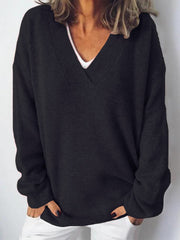 Black ribbed knit V-neck sweater with a relaxed fit, worn over a white top.