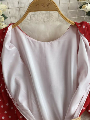 Red polka dot tiered dress with white lining and zipper detail