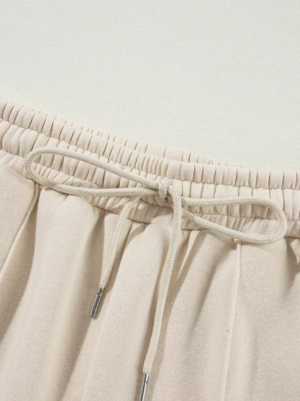 Beige cotton joggers with elastic waistband and drawstring detail