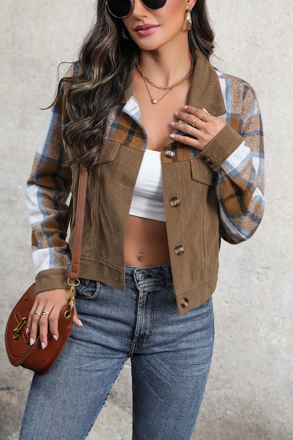 Brown corduroy jacket with plaid patchwork sleeves and button front.