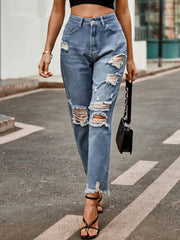Medium wash denim jeans with ripped knees and raw hem straight leg