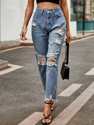 Medium wash denim jeans with ripped knees and raw hem straight leg