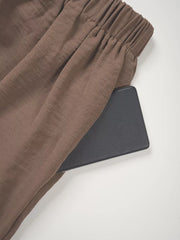 Chocolate wide-leg pants with elastic waistband and side pocket detail.