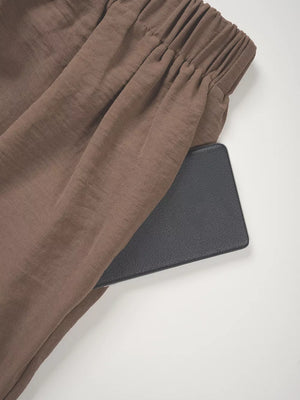 Chocolate wide-leg pants with elastic waistband and side pocket detail.
