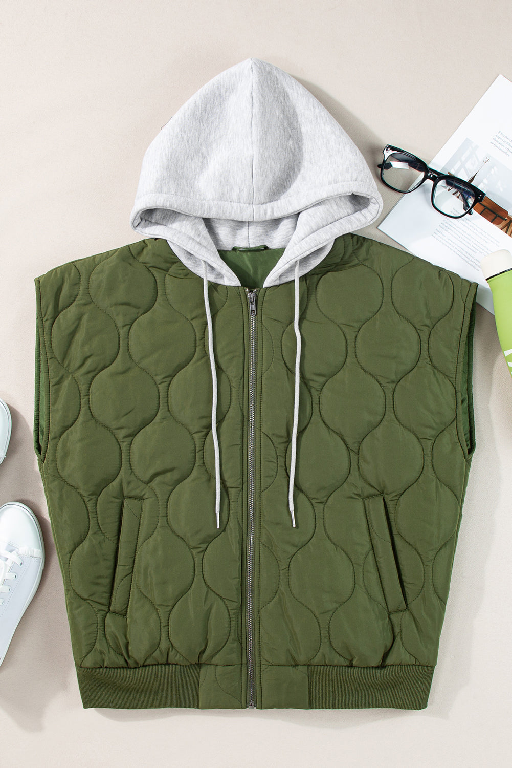Quilted moss green hooded sleeveless jacket with zipper and drawstring hood.