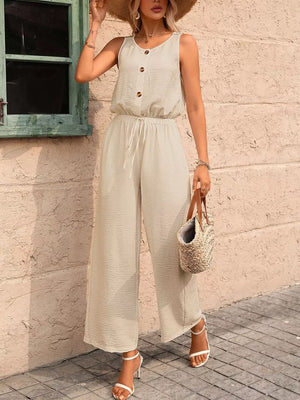 Khaki wide-leg romper with button detail, drawstring waist, and textured fabric.