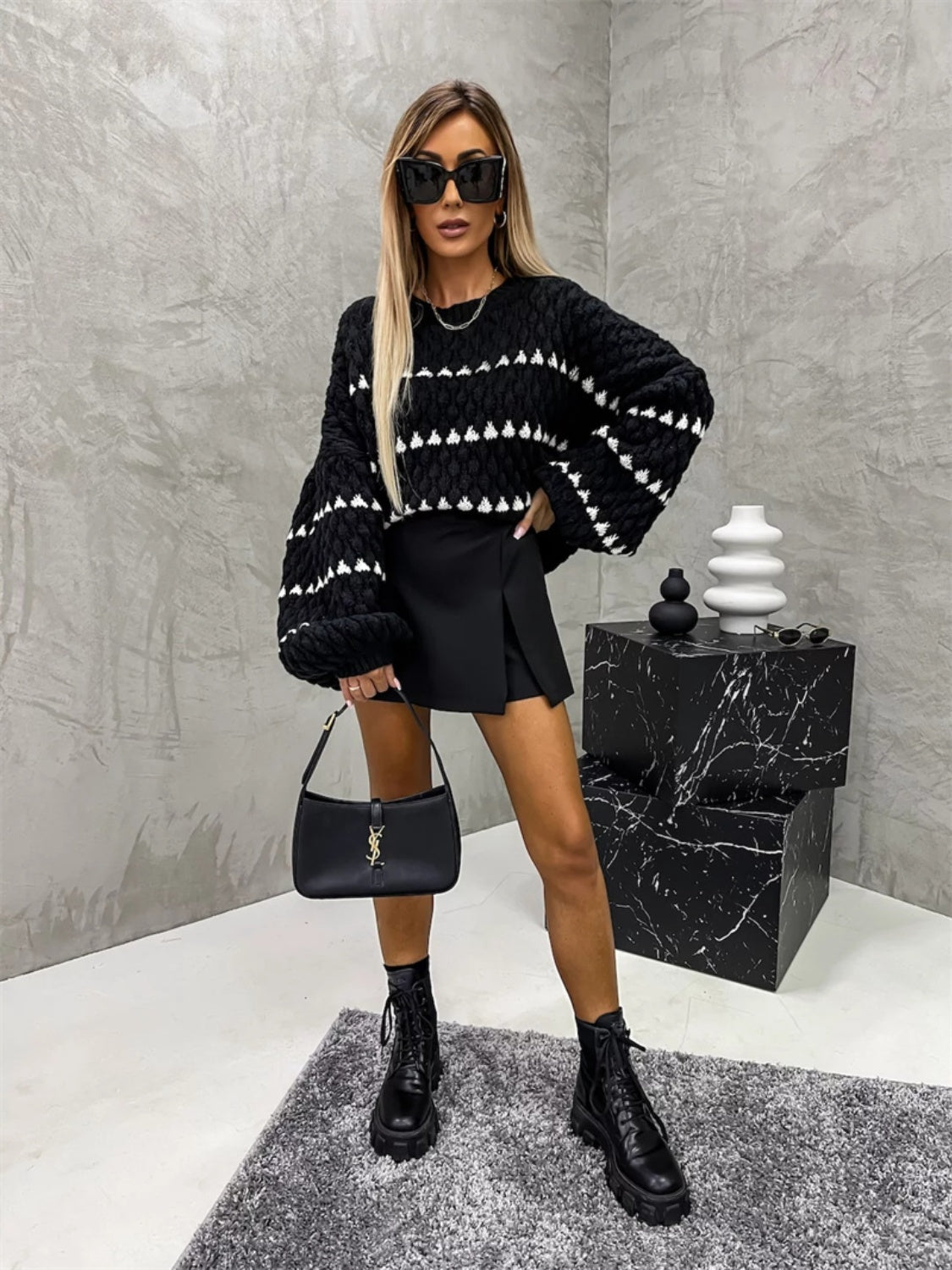 Black knit sweater with white textured stripes and balloon sleeves.