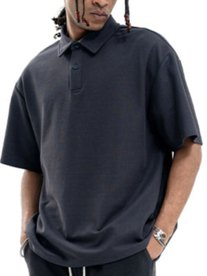 Dark gray cotton polo shirt with buttoned placket and short sleeves.