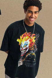 Black oversized t-shirt with a bold clown graphic featuring flames and sharp teeth.