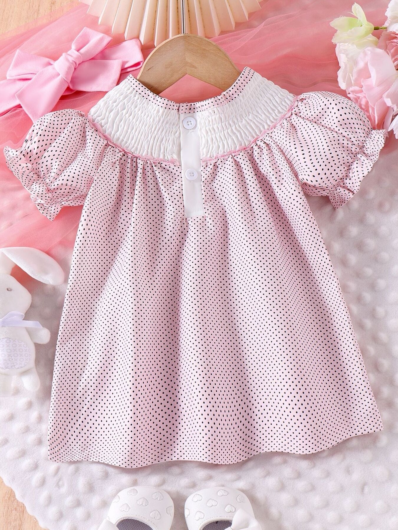 Baby dress with pink polka dots, smocked white collar, and puff sleeves.