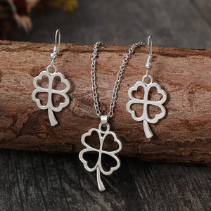 Silver four-leaf clover pendant necklace and matching dangle earrings jewelry set.