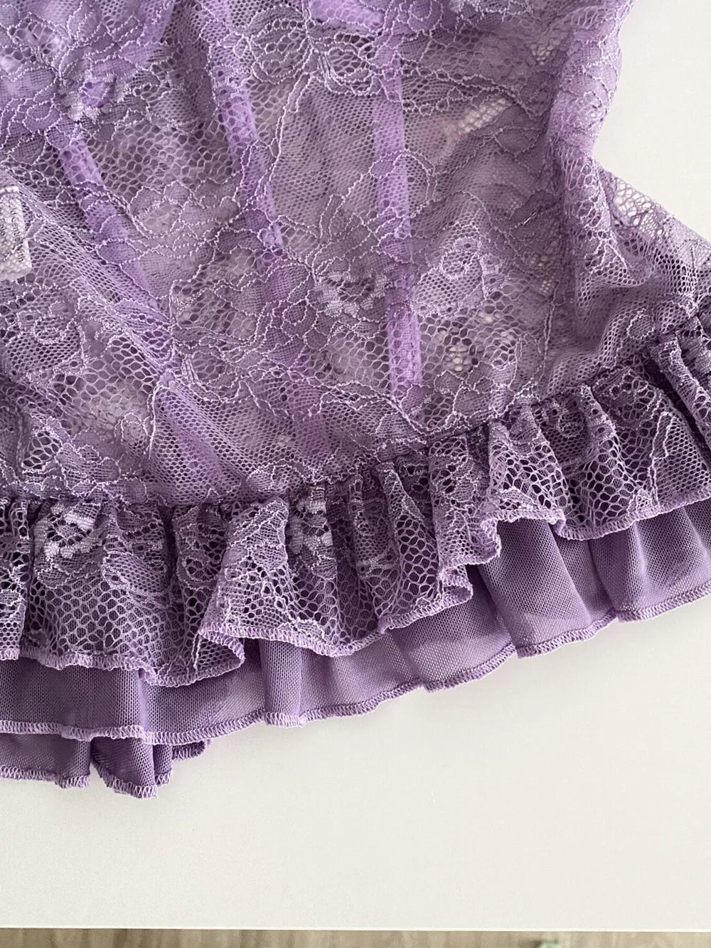 Purple lace bustier top with ruffled hem and butterfly appliques.
