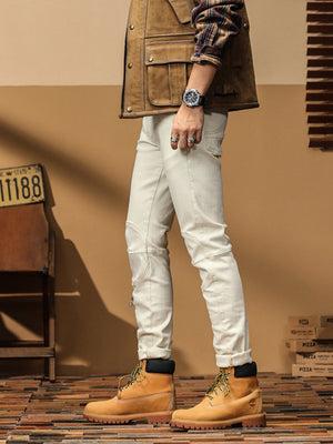 Men's light wash slim-fit denim jeans with moto-style knee details and zippers.