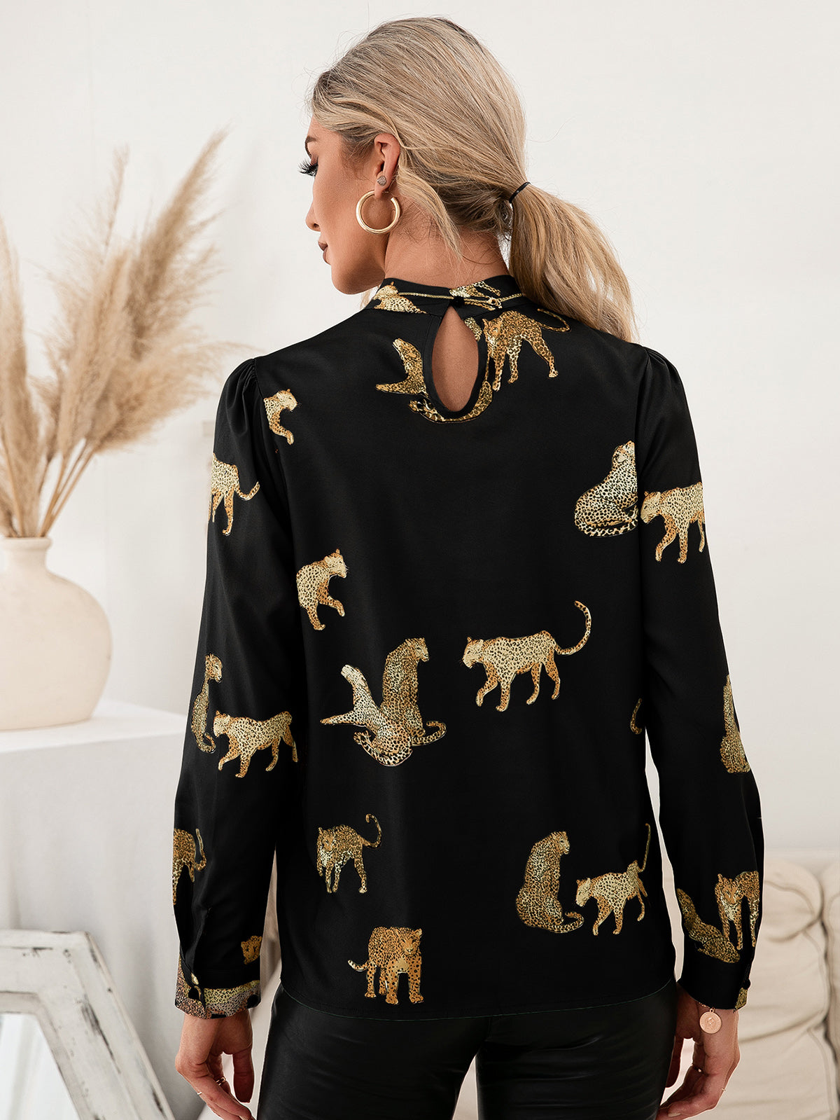 Black leopard print blouse with keyhole neck and puff sleeves.