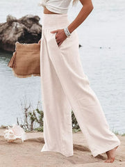 White smocked wide-leg maternity pants with pockets, styled casually.