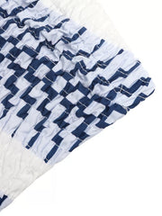 Maternity strapless romper with blue and white geometric stripe pattern and smocked detail.