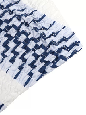 Maternity strapless romper with blue and white geometric stripe pattern and smocked detail.