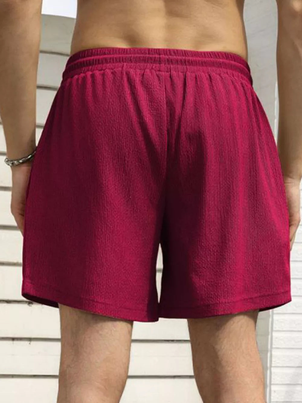Men's burgundy drawstring chino shorts with textured fabric and elastic waistband.
