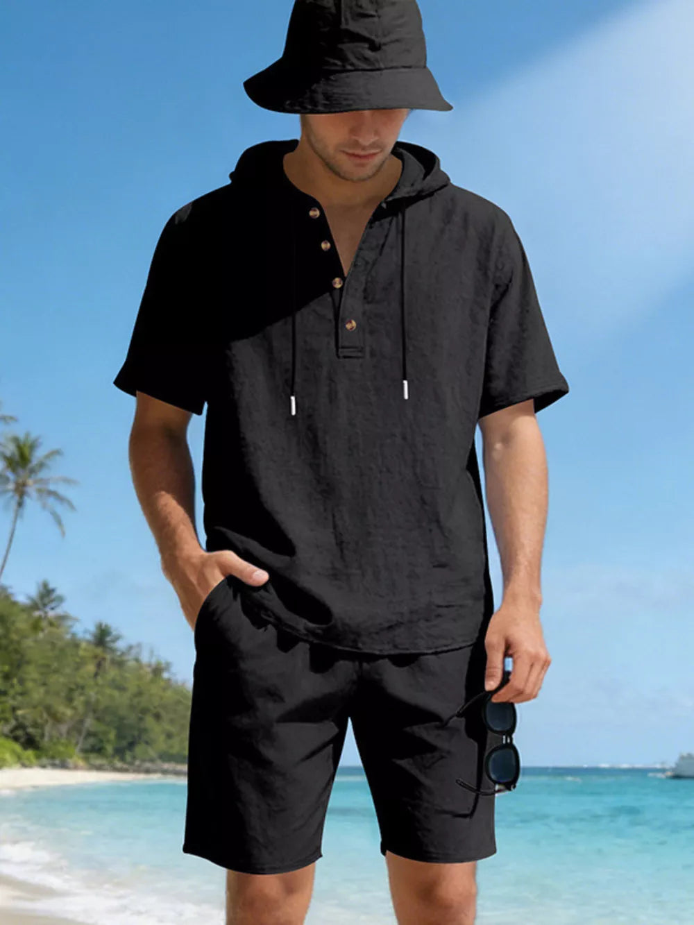 Black linen blend hooded top and shorts ensemble with button detail and drawstring.