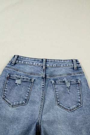 Cuffed mid-rise relaxed fit jeans in light wash denim with distressed back pockets.