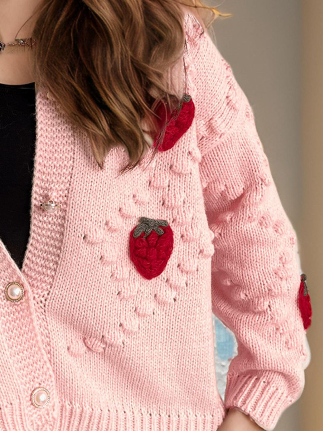 Pink knit cardigan with strawberry patchwork detail and pearl buttons