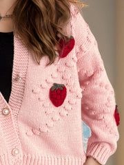 Pink knit cardigan with strawberry patchwork detail and pearl buttons