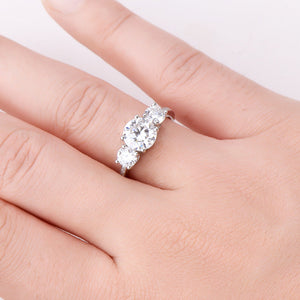 Silver ring with three round moissanite stones and a delicate band.
