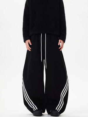 Black wide-leg sweatpants with white drawstring and triple stripe detail