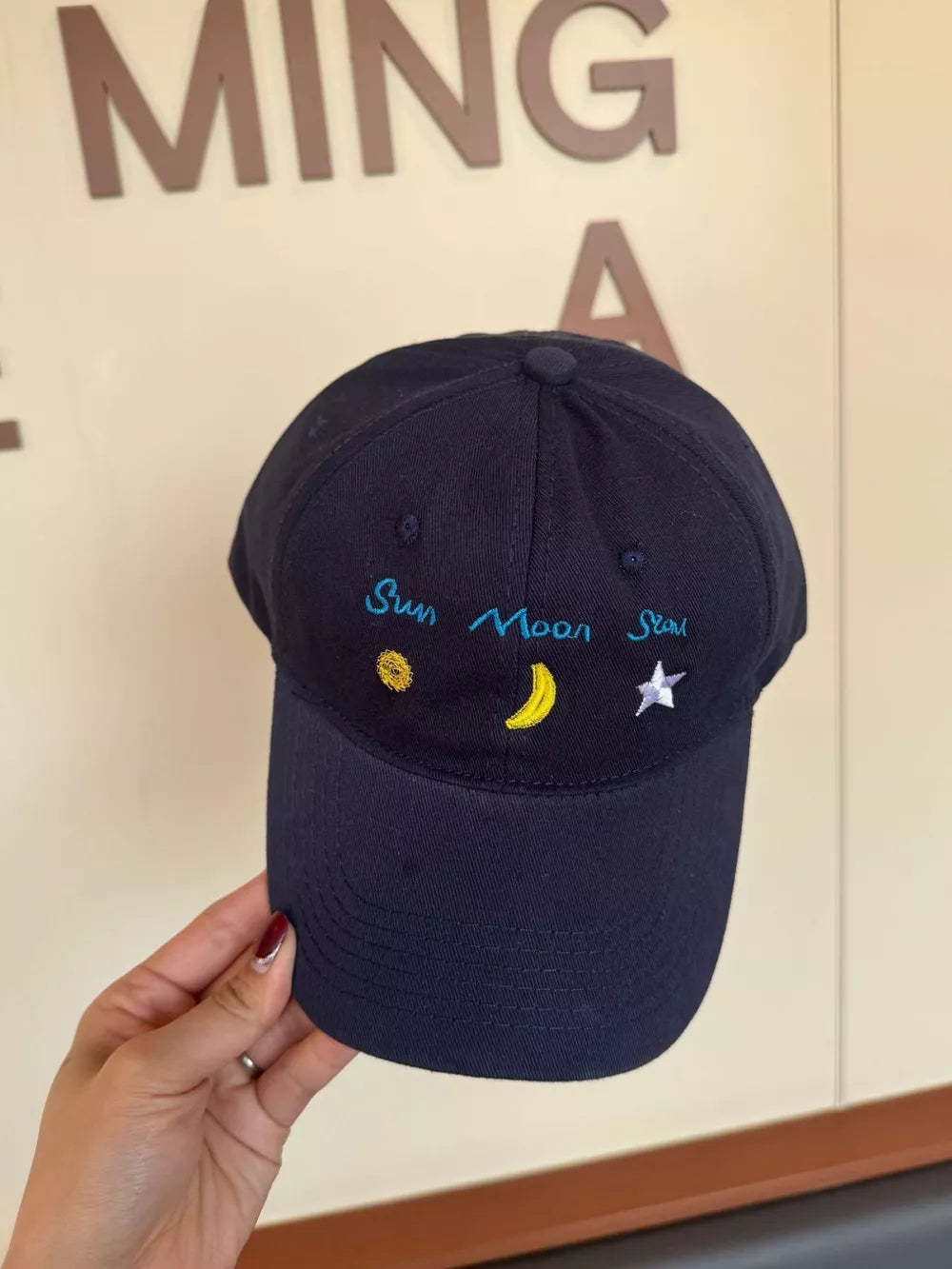 Black cotton baseball cap with embroidered sun, moon, and star details.
