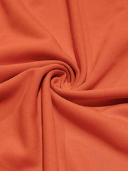 Orange cotton t-shirt fabric detail, showing texture and drape.