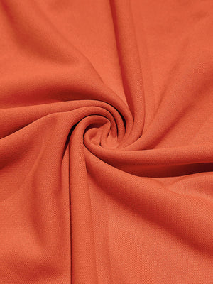 Orange cotton t-shirt fabric detail, showing texture and drape.