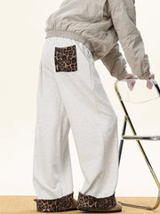 Men's gray sweatpants with leopard print trim on pocket and cuffs.