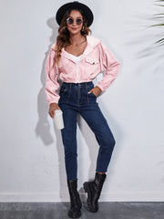 Cropped pink corduroy hooded jacket with zipper and flap pockets.