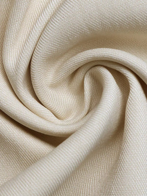 Cream maternity romper fabric detail with subtle texture and drape