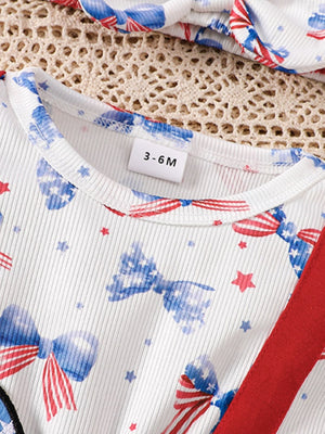 White patriotic print baby dress with ruffle sleeves and red trim.