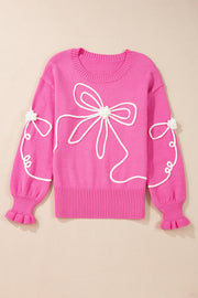 Fuchsia pink knit sweater with white embroidered bow motif and ruffled cuffs.
