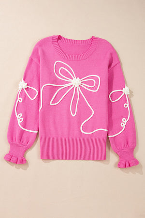 Fuchsia pink knit sweater with white embroidered bow motif and ruffled cuffs.
