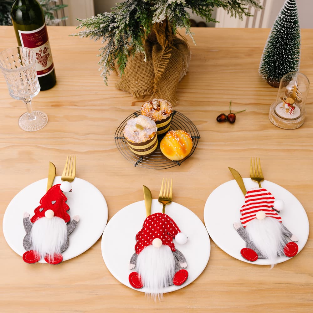 Festive gnome cutlery holders in red with white accents, a cheerful holiday table accessory.