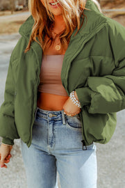 Moss green padded crop jacket with stand collar and zip front, styled with jeans.