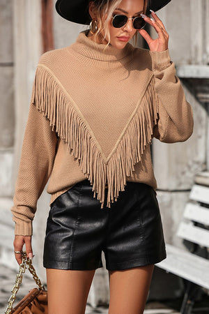 Beige turtleneck sweater with fringe detail and chevron pattern.