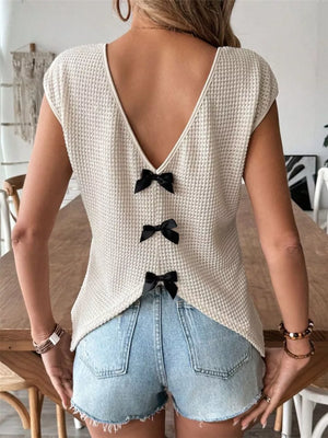 Apricot waffle knit v-neck shirt with cap sleeves and three black bow details down the back.