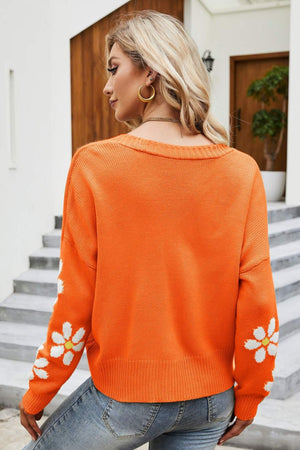 Orange knit cardigan with daisy embroidery on sleeves