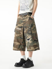 Men's camouflage cargo denim shorts with distressed details and patches.
