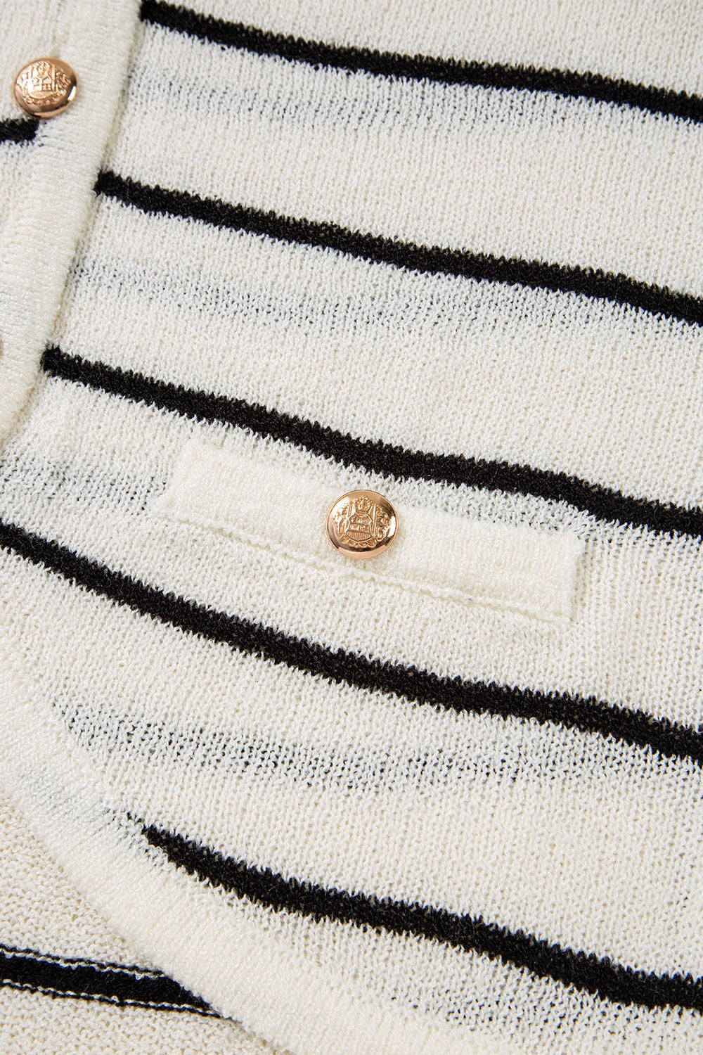 White and black striped knit vest with button detail and pocket.