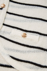 White and black striped knit vest with button detail and pocket.
