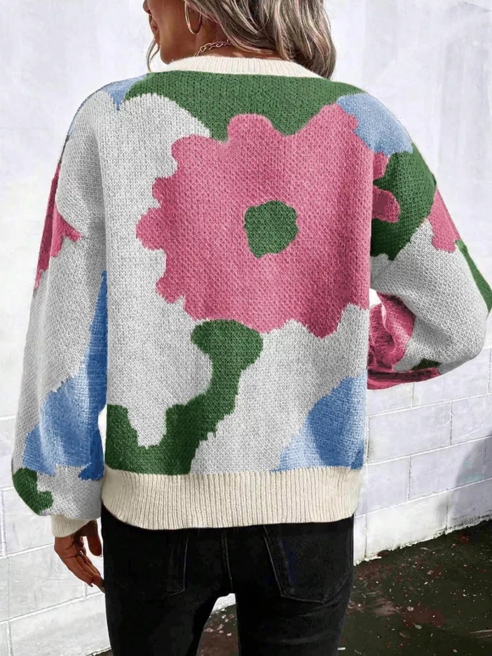 Abstract floral knit sweater with round neck in pink, green, blue, and white.