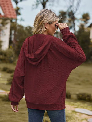 Textured knit dolman sleeve hoodie in wine with a relaxed fit and cuffed sleeves.