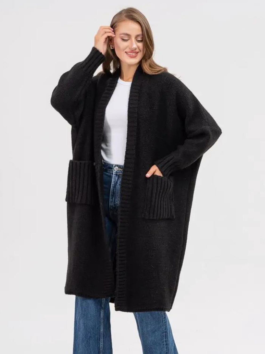 Black oversized knit cocoon cardigan with pockets and ribbed cuffs.