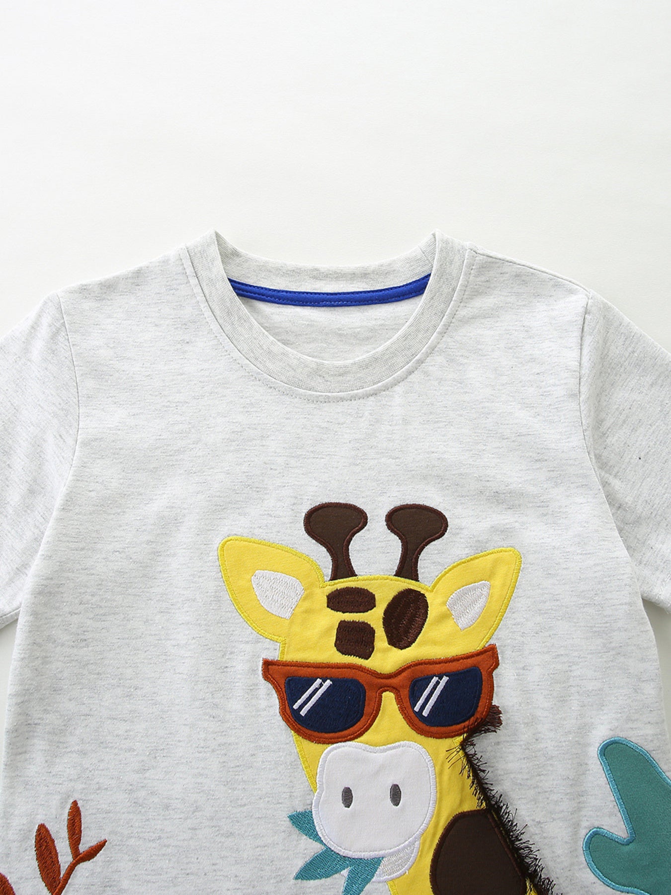 Light grey cotton toddler t-shirt with a playful giraffe graphic wearing sunglasses.