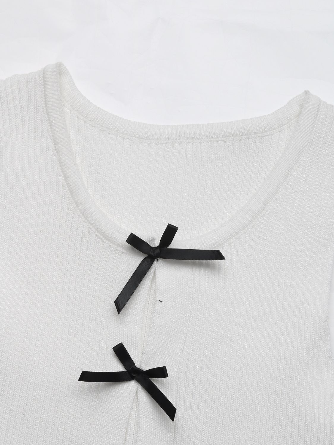 White ribbed knit tank top with black bow details at the neckline